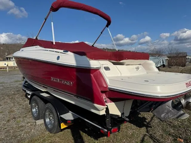 Slide: The Image of 2006 Monterey 234FS boat with red canopy on a trailer, parked outdoors. - 7
