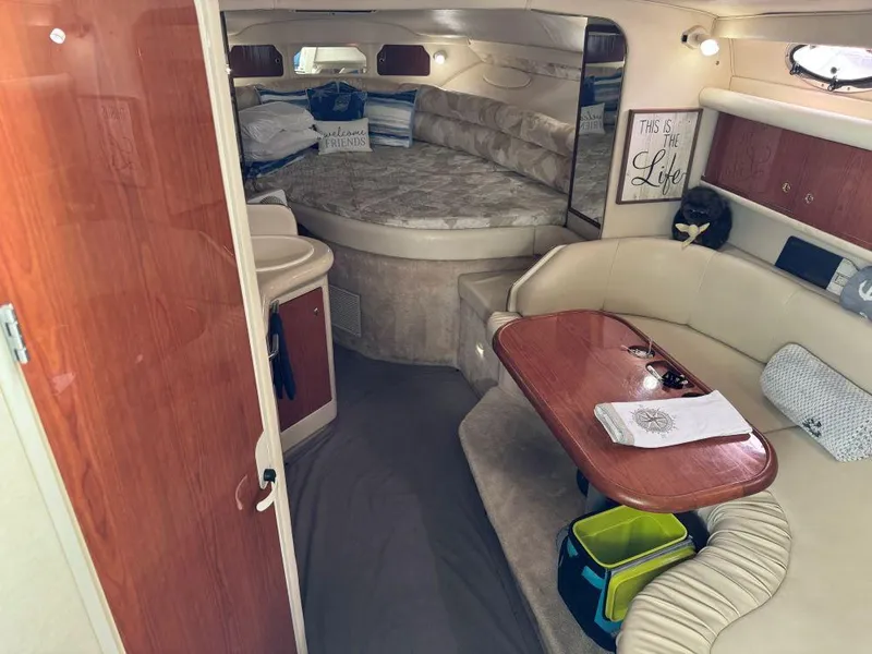 Slide: The Image of 1999 Sea Ray 330 Sundancer cabin interior with seating, table, and bed. - 11