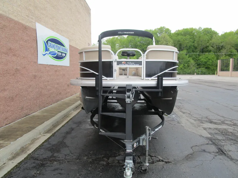 Slide: The Image of 2019 Sun Tracker SPORT FISH 22 XP3 pontoon boat on trailer, parked near a building. - 3