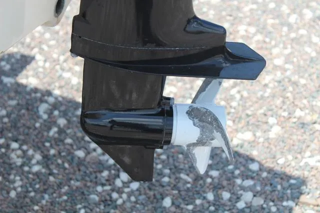 Slide: The Image of Close-up of a 2006 Gheenoe 13 boat motor propeller on gravel surface. - 10