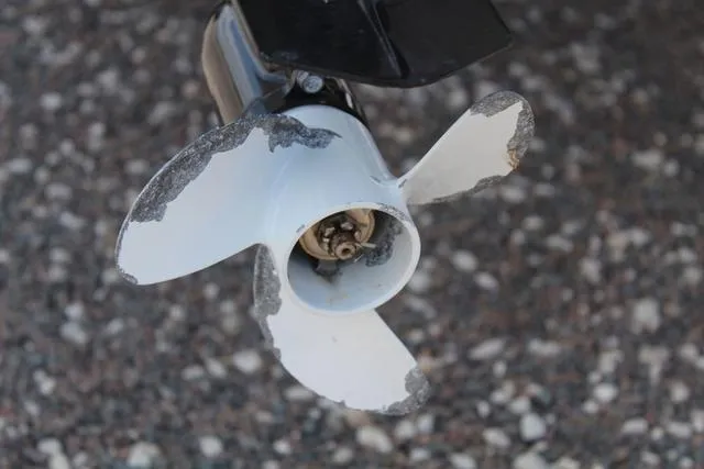 Slide: The Image of Damaged propeller of a 2006 Gheenoe 13 boat on gravel surface. - 11