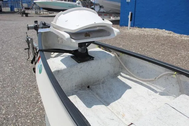 Slide: The Image of 2006 Gheenoe 13 boat with mounted equipment, parked on gravel near blue building. - 12