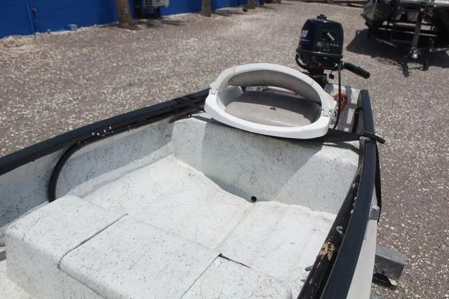 Slide: The Image of 2006 Gheenoe 13 boat interior with motor, featuring white seating and a compact design. - 13