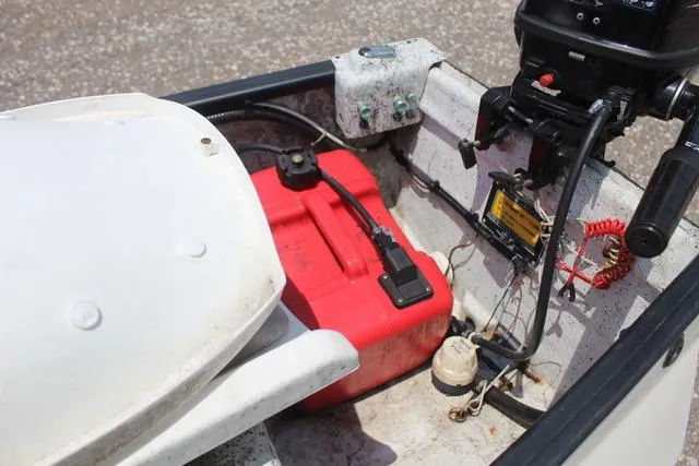 Slide: The Image of 2006 Gheenoe 13 boat interior with red fuel tank and motor controls. - 14