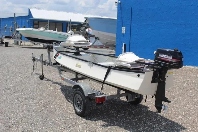 Slide: The Image of 2006 Gheenoe 13 boat on trailer with Hangkai motor, parked near blue building. - 6