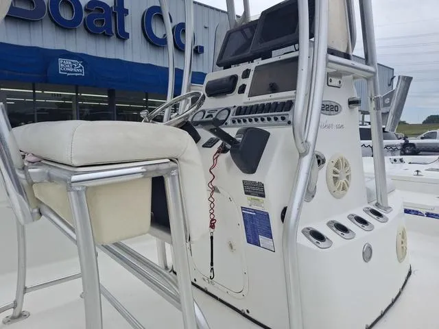 Slide: The Image of 2013 Blazer 2220 Fisherman boat console with seating and controls, outside a boat company. - 4