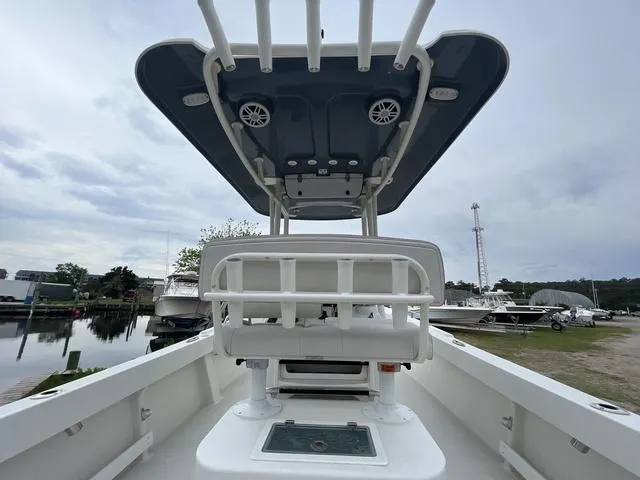 Slide: The Image of 2022 Parker 2300 SE boat interior with seating and canopy, docked near water. - 12