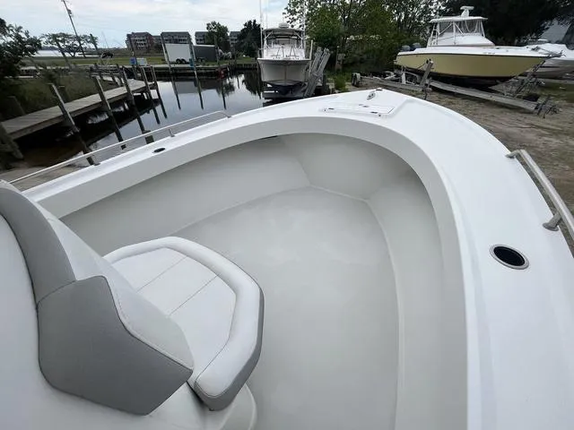 Slide: The Image of 2022 Parker 2300 SE boat interior with seating, docked near other boats. - 8