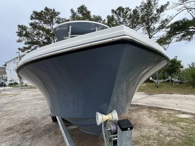 Slide: The Image of 2022 Parker 2300 SE boat on trailer, parked outdoors with trees in background. - 2