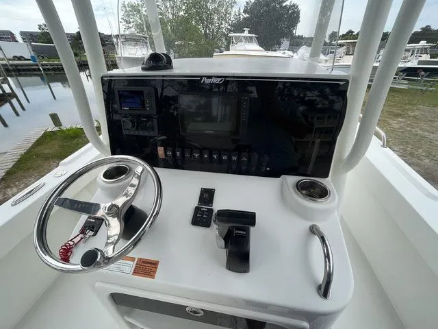 Slide: The Image of Control panel of a 2022 Parker 2300 SE boat with steering wheel and navigation equipment. - 9