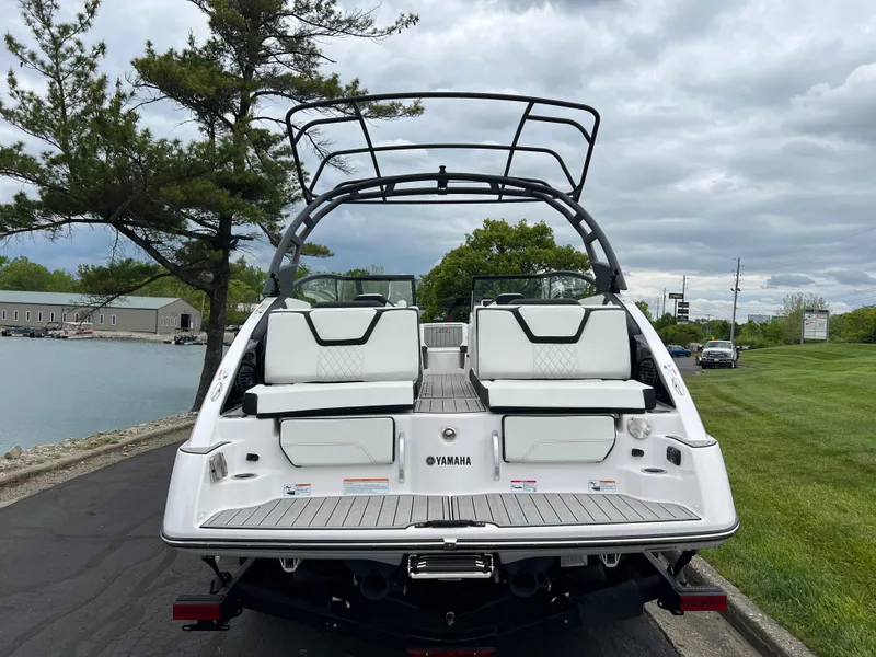 Slide: The Image of 2025 Yamaha Boats 252SD, rear view, docked near a scenic waterfront. - 5