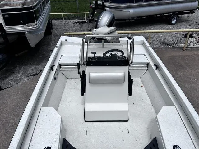 Slide: The Image of 2017 Ranger RB190 boat interior with steering console and seating, docked near other boats. - 12