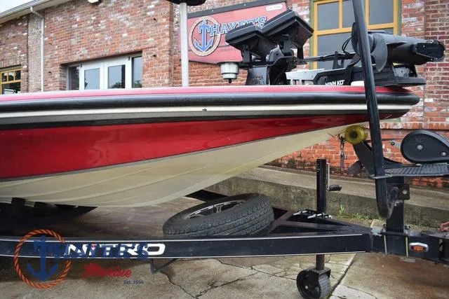 Slide: The Image of 2015 Nitro Z Series Z-8 boat on trailer, red and white hull, parked outside brick building. - 11