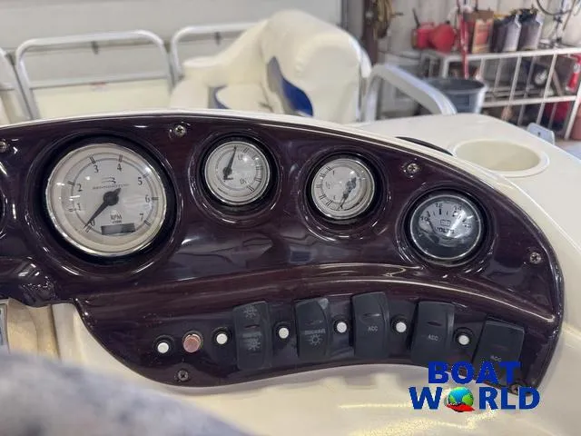 Slide: The Image of Dashboard of a 2005 Bennington 186L Pontoon with gauges and switches, Boat World logo visible. - 19
