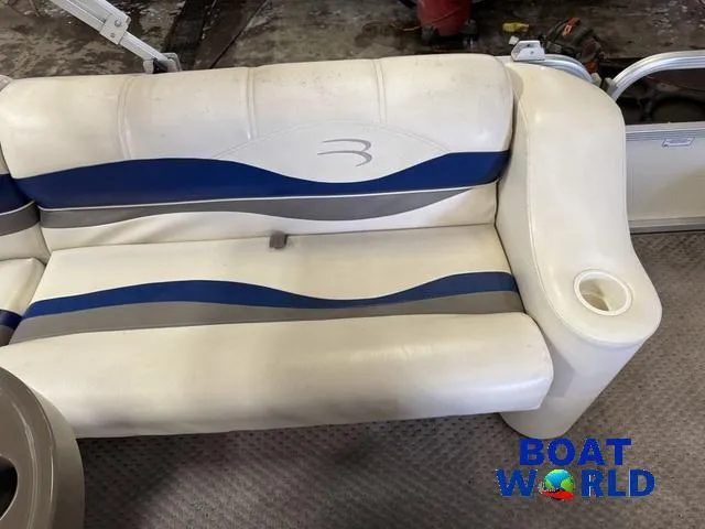 Slide: The Image of 2005 Bennington 186L Pontoon boat seat with blue and gray accents, featuring a cup holder. - 23