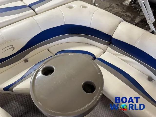 Slide: The Image of 2005 Bennington 186L Pontoon interior with blue and white seating, table, and cup holders. - 24