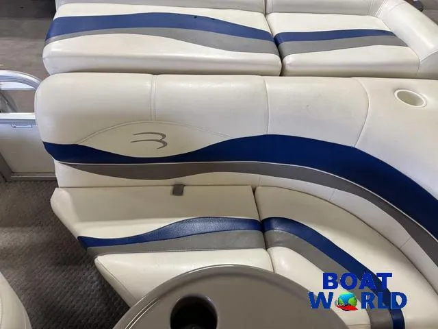 Slide: The Image of 2005 Bennington 186L Pontoon boat interior with blue and white seating, cup holder visible. - 25