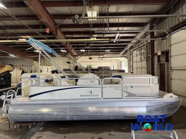 Slide: The Image of 2005 Bennington 186L Pontoon boat in a warehouse, featuring a blue canopy. - 27