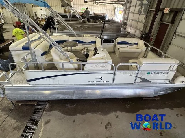Slide: The Image of 2005 Bennington 186L Pontoon boat in a showroom, featuring white and blue seating. - 4