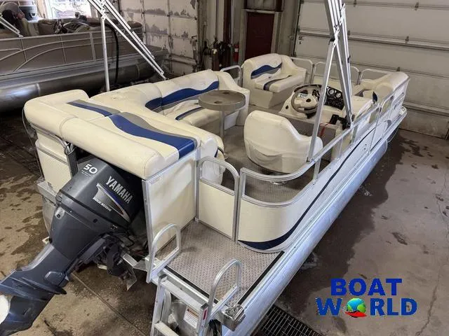 Slide: The Image of 2005 Bennington 186L Pontoon boat with Yamaha motor, white seating, and steering console in a garage. - 7