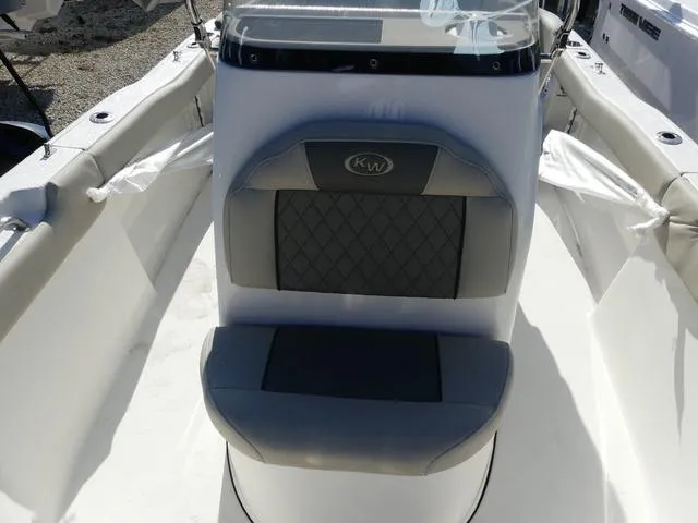 Slide: The Image of Key West 203 FS 2025 boat seat with gray cushioning and KW logo. - 11