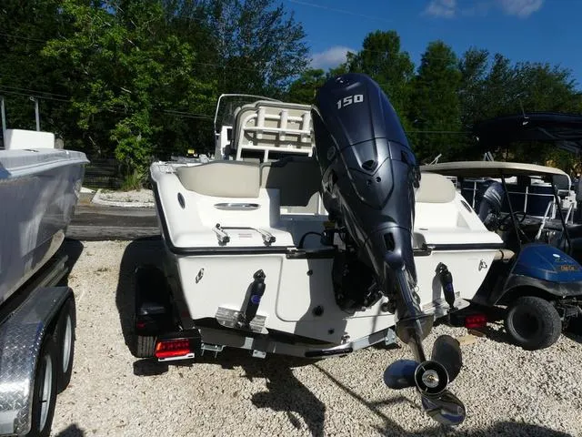 Slide: The Image of 2025 Key West 203 FS boat with 150 HP engine, parked on gravel. - 4