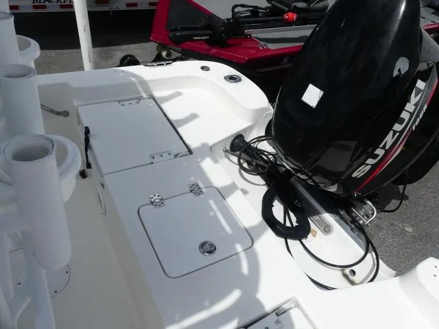 Slide: The Image of 2013 NauticStar 1910 NauticBay boat with Suzuki outboard motor, featuring rod holders and storage compartments. - 10