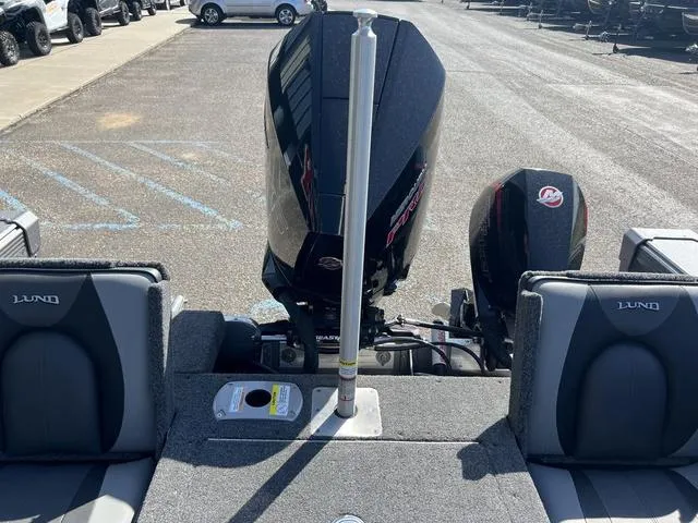 Slide: The Image of Lund 1975 Tyee Sport 2023 boat with dual outboard motors, parked on asphalt. - 10