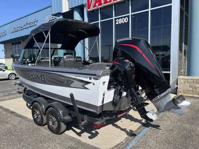 Slide: The Image of 2023 Lund 1975 Tyee Sport boat with outboard motor, parked outside dealership. - 13