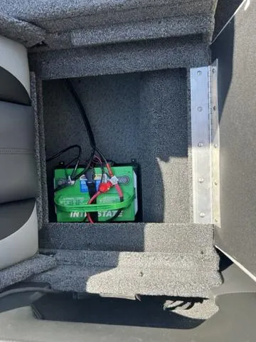 Slide: The Image of Battery compartment of 2023 Lund 1975 Tyee Sport boat, featuring a green battery. - 14