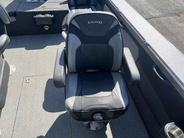 Slide: The Image of Lund 1975 Tyee Sport 2023 boat seat, black and gray, on deck. - 17