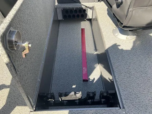 Slide: The Image of Interior of 2023 Lund 1975 Tyee Sport boat showing storage compartment and measuring tool. - 27