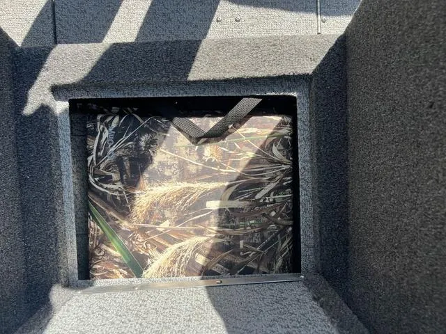 Slide: The Image of Interior storage compartment of 2023 Lund 1975 Tyee Sport boat, featuring camo design. - 29