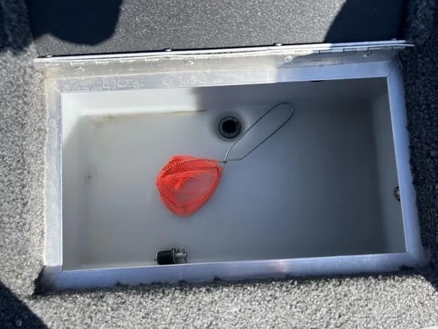 Slide: The Image of Open storage compartment in 2023 Lund 1975 Tyee Sport boat with red mesh bag. - 33