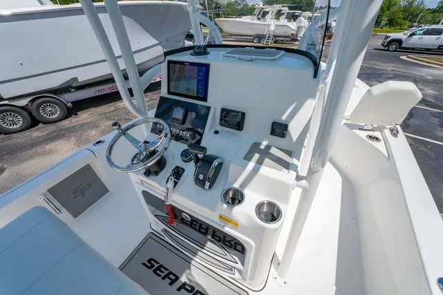 Slide: The Image of 2025 Sea Pro 250 Bay boat console with steering wheel, controls, and navigation display. - 15