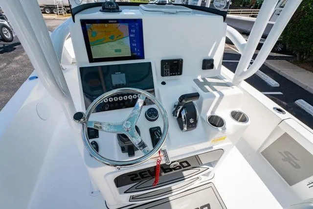 Slide: The Image of 2025 Sea Pro 250 Bay boat console with steering wheel, navigation screen, and controls. - 16