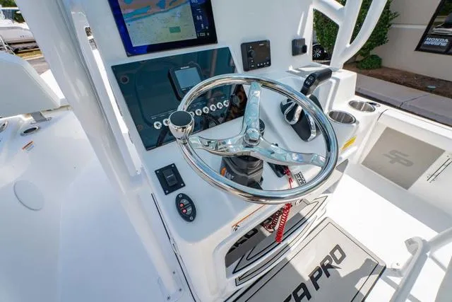 Slide: The Image of 2025 Sea Pro 250 Bay boat dashboard with steering wheel and navigation controls. - 18