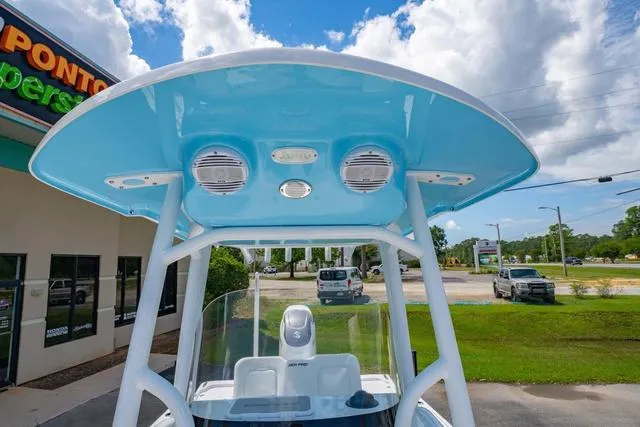 Slide: The Image of 2025 Sea Pro 250 Bay boat with blue T-top and speakers, parked outdoors. - 28