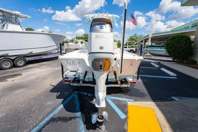 Slide: The Image of 2025 Sea Pro 250 Bay boat with Suzuki outboard motor in a parking lot. - 4