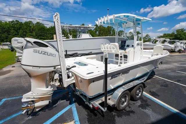 Slide: The Image of 2025 Sea Pro 250 Bay boat with Suzuki engine on a trailer, parked outdoors. - 5