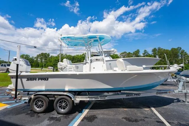 Slide: The Image of 2025 Sea Pro 250 Bay boat on trailer under clear blue sky. - 6