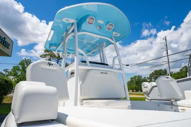 Slide: The Image of 2025 Sea Pro 250 Bay boat with blue T-top under a clear sky. - 8