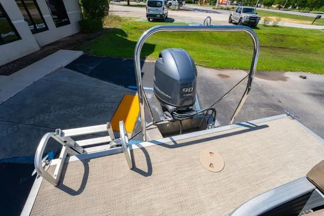 Slide: The Image of 2019 Bennington 20 SX pontoon boat with 90 HP outboard motor, docked outdoors. - 13