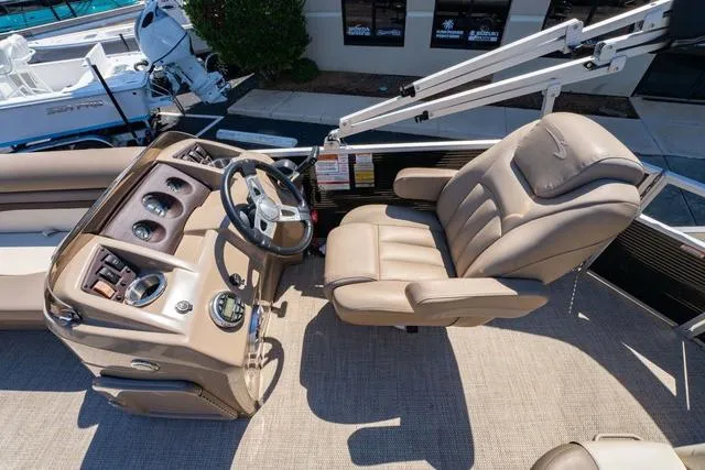 Slide: The Image of Captain's seat and helm of 2019 Bennington 20 SX pontoon boat, featuring beige upholstery. - 15