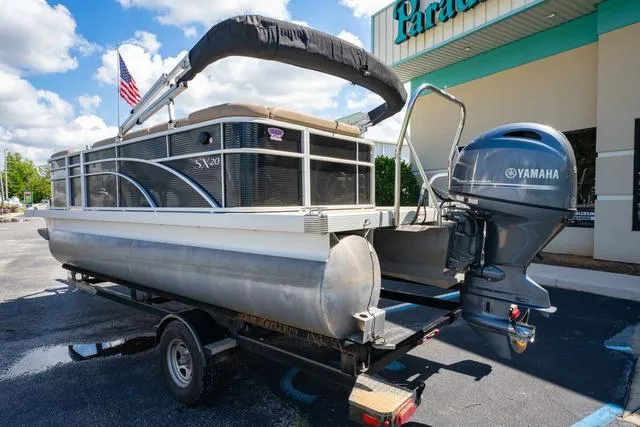 Slide: The Image of 2019 Bennington 20 SX pontoon boat with Yamaha engine on a trailer, parked outdoors. - 3