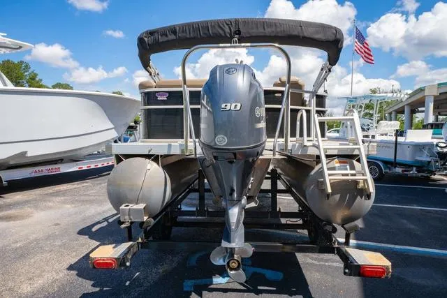 Slide: The Image of 2019 Bennington 20 SX pontoon boat with 90 HP engine, parked on a trailer. - 4