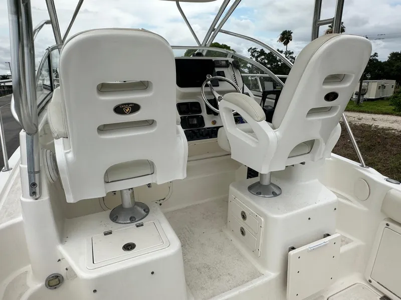 Slide: The Image of 2008 Century 2600 Walkaround boat cockpit with dual white captain chairs and steering console. - 10
