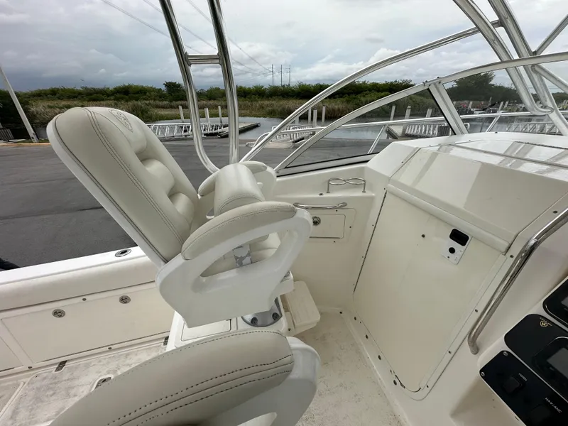 Slide: The Image of 2008 Century 2600 Walkaround boat interior with white seating and control panel. - 13