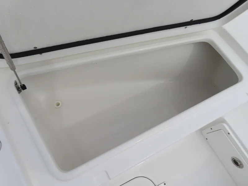 Slide: The Image of 2023 Sea Hunt Gamefish 25 storage compartment, open lid, spacious interior. - 12