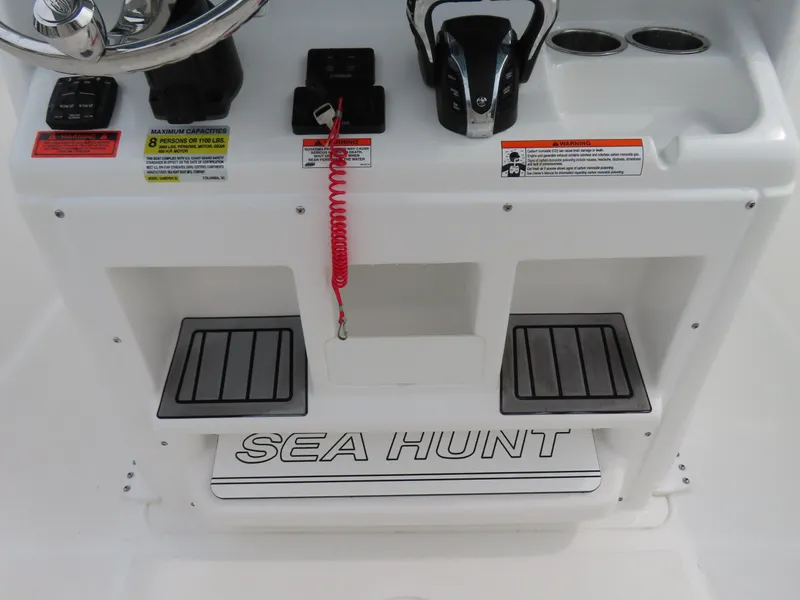 Slide: The Image of 2023 Sea Hunt Gamefish 25 boat console with controls and Sea Hunt branding. - 27